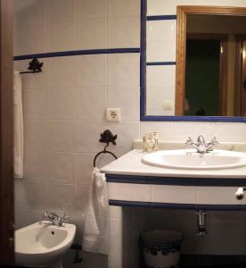 La salle de bains blanche est pourvue d'un lavabo et d'un miroir. dans l'établissement Casa Jacinta, à Bimenes