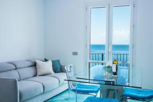 ein Wohnzimmer mit einem Sofa und einem Glastisch in der Unterkunft Villa Venere - Amalfi Coast in Cetara