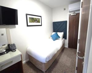 Habitación de hotel con cama y teléfono en The Bailie en Cavan