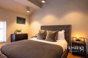 a bedroom with a large bed with pillows on it at Stylish Luxury Apartment in The Centre of Henley in Henley on Thames