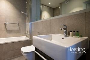 a bathroom with a white sink and a toilet at Stylish Luxury Apartment in The Centre of Henley in Henley on Thames