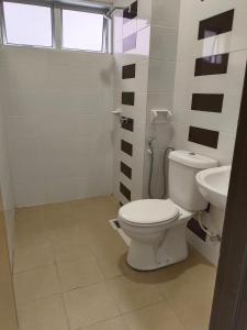 La salle de bains est pourvue de toilettes et d'un lavabo. dans l'établissement 8Pax comfortable setia residen, à Sitiawan