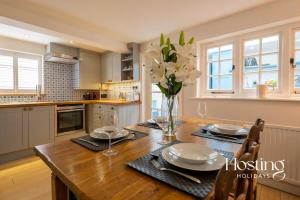 een keuken met een houten tafel en een vaas met bloemen bij Spacious Luxury Cottage With Roof Terrace Close To The River Thames in Henley on Thames