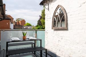 un patio con una mesa y una ventana en Spacious Luxury Cottage With Roof Terrace Close To The River Thames en Henley on Thames