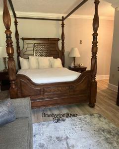 a bed with a wooden frame in a room at Brandywine River Hotel in Chadds Ford