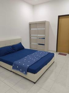 - une chambre avec un lit doté de draps bleus et une armoire dans l'établissement 8Pax comfortable setia residen, à Sitiawan