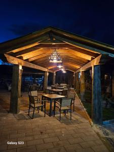 a wooden pavilion with tables and chairs at night at Cornatel Médulas in Borrenes