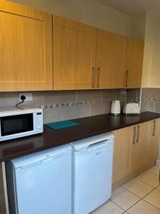 a kitchen with a refrigerator and a microwave at Lovely 2-Bed House in Liverpool in Liverpool