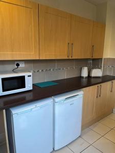 a kitchen with a white microwave and a dishwasher at Lovely 2-Bed House in Liverpool in Liverpool