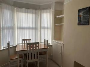 Lovely 2-Bed House in Liverpool في ليفربول: غرفة طعام مع طاولة وكراسي خشبية