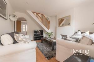 uma sala de estar com um sofá branco e uma televisão em Stunning Character House In The Centre of Henley em Henley on Thames