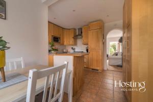 a kitchen with wooden cabinets and a table and a counter at Stunning Character House In The Centre of Henley in Henley on Thames