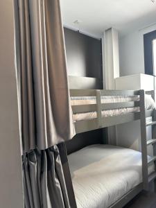 1 dormitorio con literas y cortina en Hostel Alicante A-cero Living, en Alicante