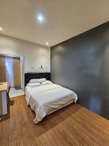 una camera da letto con un grande letto bianco con una parete nera di Hotel Bodhi a Tanjungselor