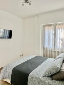 een witte slaapkamer met een bed en een raam bij La Casetta di Marika in Marina di Cerveteri