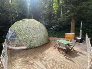 ein Zelt auf einer Terrasse mit einem Tisch und Stühlen in der Unterkunft Orion - A La Bul'étoile in Loulans-Verchamp