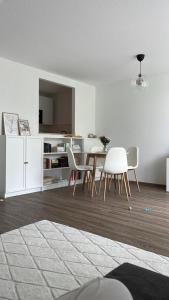 a white living room with a table and chairs at Zentrale, 55m2, helle 2 Zimmer Whg nähe Messe in Düsseldorf