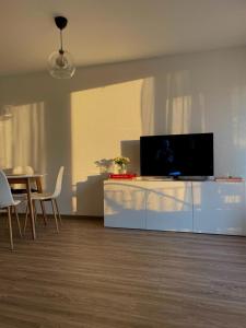 a living room with a tv on a white entertainment center at Zentrale, 55m2, helle 2 Zimmer Whg nähe Messe in Düsseldorf +30 photos