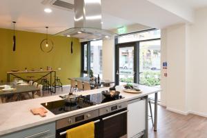 a kitchen with a stove top oven next to a dining room at Modern and Bright Ensuite at St Mungo's in Glasgow for Students Only in Glasgow