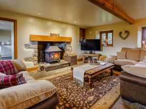 a living room with a fireplace and a couch at 4 Bed in Abergavenny 88014 in Llanover