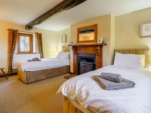 a bedroom with two beds and a fireplace in it at 4 Bed in Abergavenny 88014 in Llanover