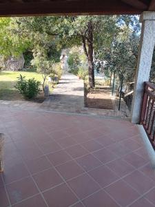 a porch with a bench and a walkway with trees at Bandi House in San Teodoro