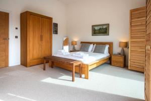 1 dormitorio con 1 cama y armario de madera en Waters Edge 15, Kingsholm P en South Cerney