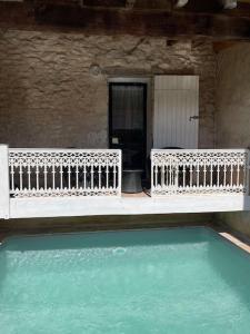SigoulèsにあるGîte avec piscine et terrasse privativeのスイミングプールと白いベンチ2つ付きの家