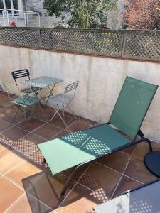 a table and chairs and a laptop on a patio at Gîte avec piscine et terrasse privative in Sigoulès