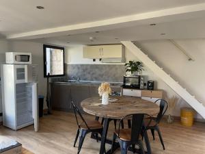 a kitchen and dining room with a table and chairs at Gîte avec piscine et terrasse privative in Sigoulès