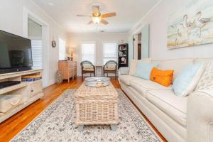 ein Wohnzimmer mit einer weißen Couch und einem Tisch in der Unterkunft The Cottage - Downtown Rockport in Rockport