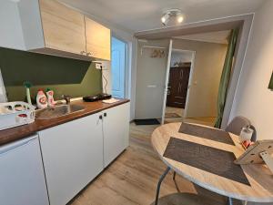 a kitchen with a sink and a table in a room at Hédi Vendégház Eger in Eger