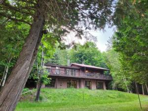 una casa grande con terraza en el bosque en Private Rustic Lodge w/ Lakefront Views en Minden