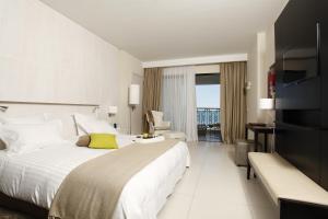 a hotel room with a large bed with a yellow pillow at Dar El Marsa Hotel & Spa in La Marsa