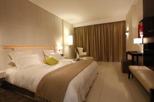 a hotel room with a large bed and a chair at Dar El Marsa Hotel & Spa in La Marsa