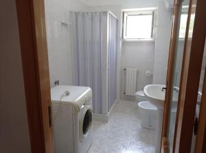 a white bathroom with a washing machine and a sink at Casa Piano Piccolo 3 in Vieste
