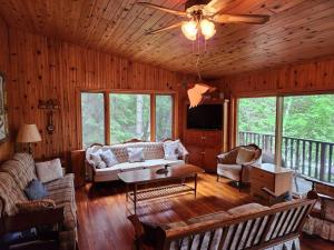 sala de estar con sofá y ventilador de techo en Private Rustic Lodge w/ Lakefront Views en Minden