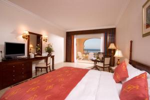 a hotel room with a bed and a television at Caribbean World Resort Soma Bay in Hurghada