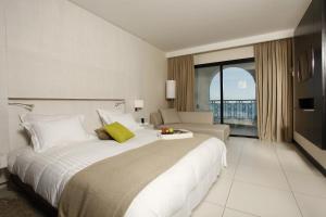 a hotel room with a large bed and a couch at Dar El Marsa Hotel & Spa in La Marsa