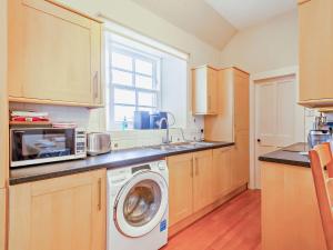 a kitchen with a washing machine and a microwave at 2 Bed in Conon Bridge CA387 in Cononbridge