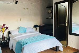 a bedroom with a bed with a blue and white blanket at Hotel Verano Resort San Gil in San Gil