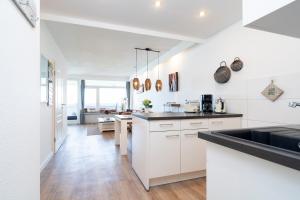 a kitchen with white cabinets and a black counter top at Panoramic App A14-zehn in Sierksdorf