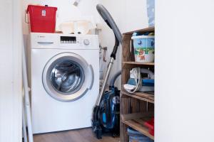 a washing machine in a laundry room next to a shelf at Panoramic App A14-zehn in Sierksdorf