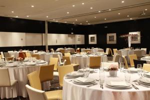 a room filled with tables and chairs with white tablecloths at Dar El Marsa Hotel & Spa in La Marsa