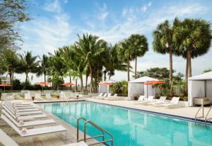 uma piscina com espreguiçadeiras e palmeiras em Residence Inn by Marriott Miami Beach Surfside em Miami Beach