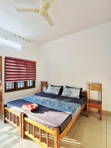 a bedroom with a bed and a chair at TROPICAL STORIES in Varkala