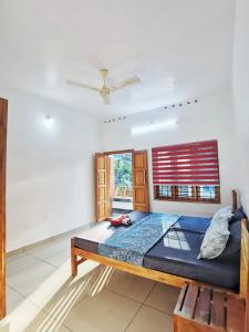 a large bed in a room with a window at TROPICAL STORIES in Varkala