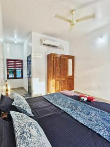 a large bed in a room with a ceiling fan at TROPICAL STORIES in Varkala