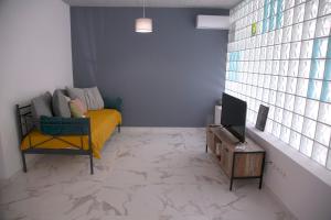 Il comprend un salon doté d'un canapé et d'une télévision. dans l'établissement Kolonaki modern flat 1 bedroom 2 pers by MPS, à Athènes