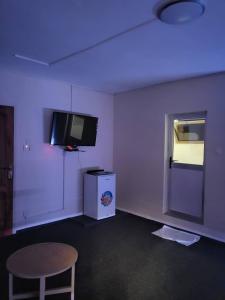 a room with a tv and a table and a chair at Hôtel particulier HP in Conakry